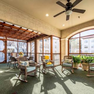 A cozy sunroom with comfortable seating, indoor plants, and large windows allowing natural light to fill the space.