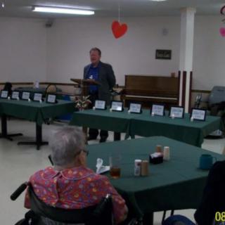 A community event in a decorated room with tables and chairs.