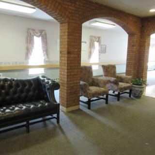 A cozy waiting area with comfortable seating and brick archways.