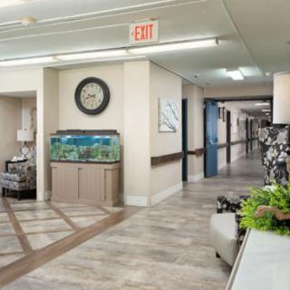A well-lit hallway featuring an aquarium and a clock on the wall.