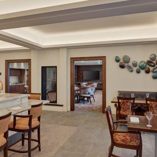 A modern dining area with a bar counter and decorative wall art.