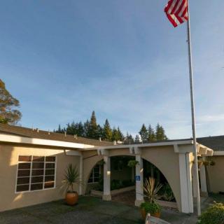 A building entrance with an American flag displayed on a flagpole.