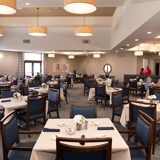 A spacious and inviting dining area featuring neatly arranged tables and warm lighting.