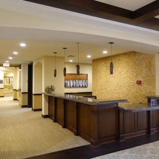 A modern lobby with a reception counter and warm lighting.