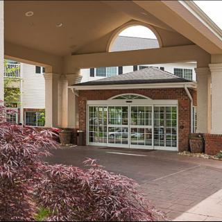 Entrance of a modern building with a landscaped driveway.
