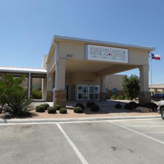 A commercial building with a welcoming entrance and clear signage, set against a clear blue sky.