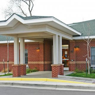 The front entrance of a brick building with a covered walkway.