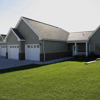 A suburban house with a well-maintained lawn and attached garages.