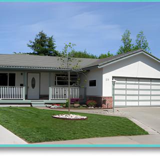 A suburban house with a well-maintained front yard and attached garage.