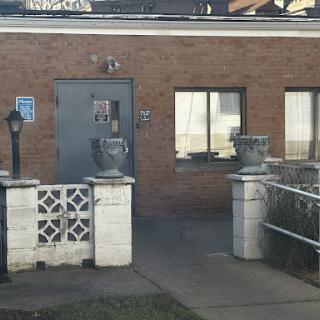 View of an entrance to a brick building with planters on either side.