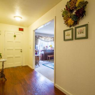 A cozy hallway with wall decorations, leading into a warmly lit room.