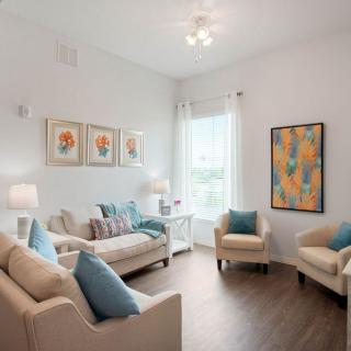 A bright and cozy living room with contemporary furniture and colorful artwork.