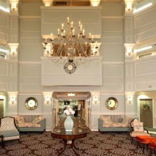 A luxurious hotel lobby featuring a grand chandelier and elegant furnishings.