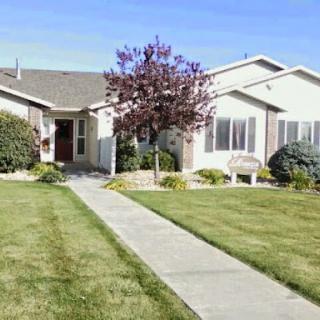 A charming residential home with a well-maintained front yard and a clear blue sky.
