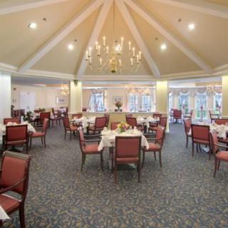 An elegantly designed dining area featuring a chandelier and neatly arranged tables and chairs.
