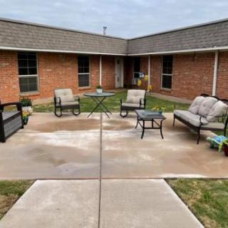 A cozy patio area with outdoor seating surrounded by a brick building.