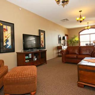 A cozy living room with leather furniture, a television, and decorative artwork.