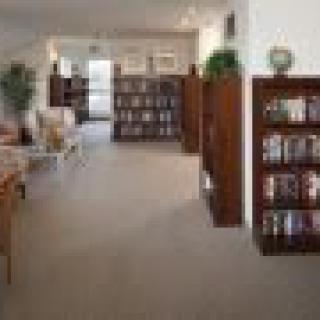 A cozy library interior with wooden bookshelves and comfortable seating.
