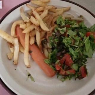 A plate with fries, a carrot, and a side of salad.