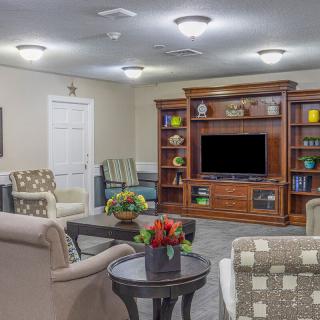 A cozy living room with comfortable seating and a wooden entertainment center.