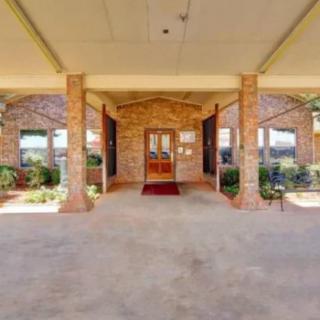A covered entrance with brick columns leading to a building's front door.