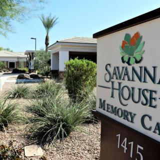 Entrance to Savannah House Memory Care facility surrounded by desert landscaping.