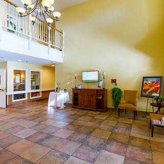 A spacious lobby area with a chandelier and tiled flooring.
