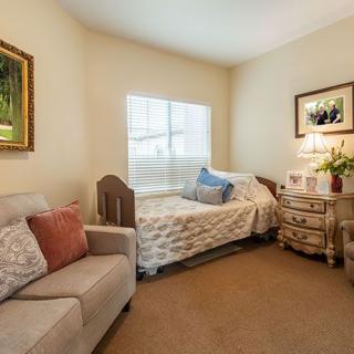 A cozy bedroom with a bed, sofa, and decorative items.