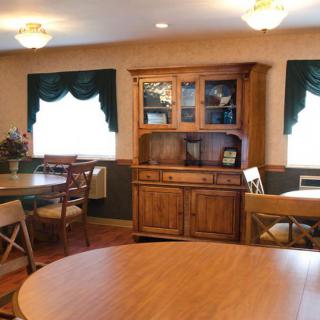 A cozy dining room with wooden furniture and elegant window curtains.