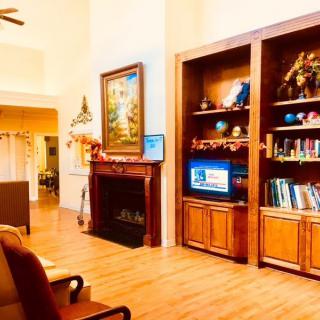 A cozy living room with a fireplace, bookshelf, and a television.