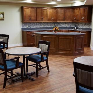A cozy dining area with wooden kitchen cabinets and a tiled backsplash.