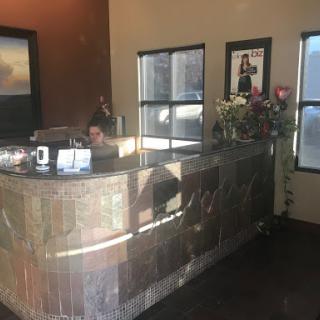 A welcoming reception area featuring a front desk adorned with flowers and artwork.