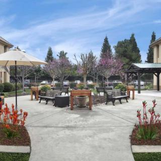 A beautifully landscaped courtyard with outdoor furniture and colorful flowers.