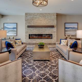 A modern living room featuring elegant sofas, a central coffee table, and a cozy fireplace.