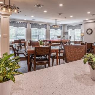 A spacious dining area with wooden furniture, large windows, and modern lighting.