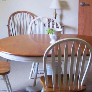 A simple dining area with a wooden table, chairs, and a small potted plant.
