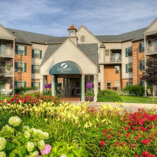 A beautifully landscaped entrance to an apartment building with a variety of colorful flowers.