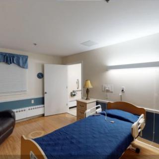 A hospital room with a single patient bed and essential furnishings.