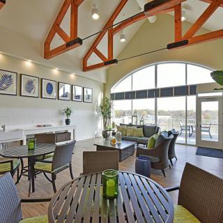 A modern lounge area with high ceilings, large windows, and contemporary furniture.
