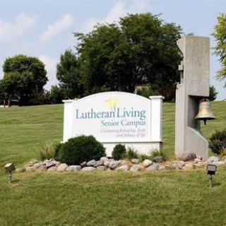 Lutheran Living Senior Campus sign in a landscaped outdoor setting.