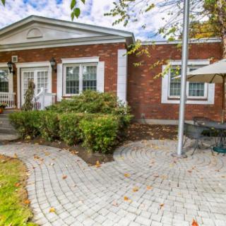 A charming brick house with a tidy patio and well-maintained garden.