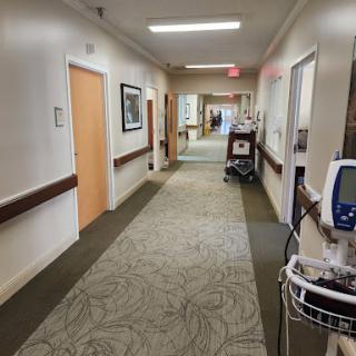 A view of a hospital hallway featuring medical equipment and patient rooms.