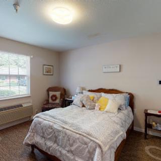 A cozy and inviting bedroom featuring a comfortable bed with decorative pillows and natural light streaming through the window.