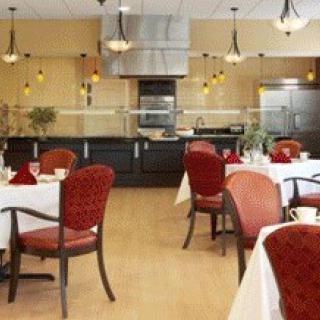 A well-lit, empty restaurant dining area with neatly arranged tables and chairs.