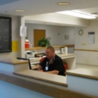 A person working at a reception desk with a computer in an office setting.
