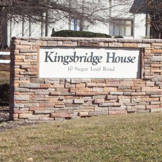 Entrance sign for Kingsbridge House displayed on a brick wall.
