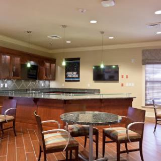 A modern kitchen and seating area featuring a bar counter, chairs, and contemporary decor.