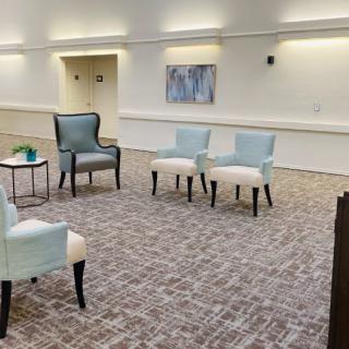 A modern, minimalist seating area with a set of chairs arranged on a patterned carpet.