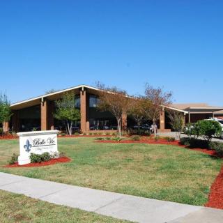 A sunny day outside a school building with well-maintained landscaping.