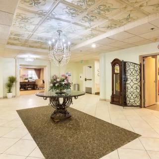 Elegant lobby area with ornate ceiling design and chandelier.